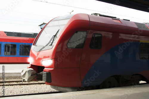 Modern high-speed train on a clear day with motion blur. Beautiful railway station with modern red commuter train.