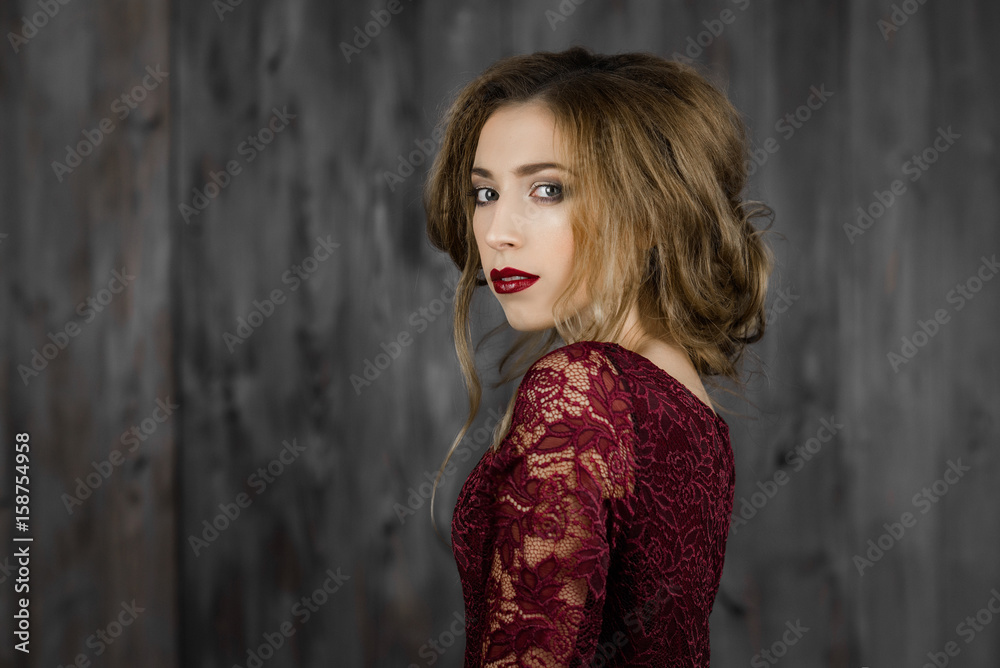 Beautiful elegant lady standing in a red long evening dress Beautiful elegant lady standing in a red long evening dress