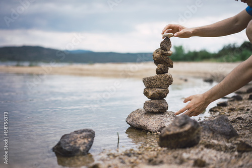 Hands making stone tower photo