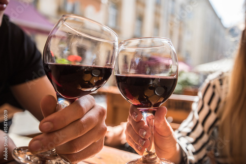 Young couple with glasses of red wine in a restaurant with city view
