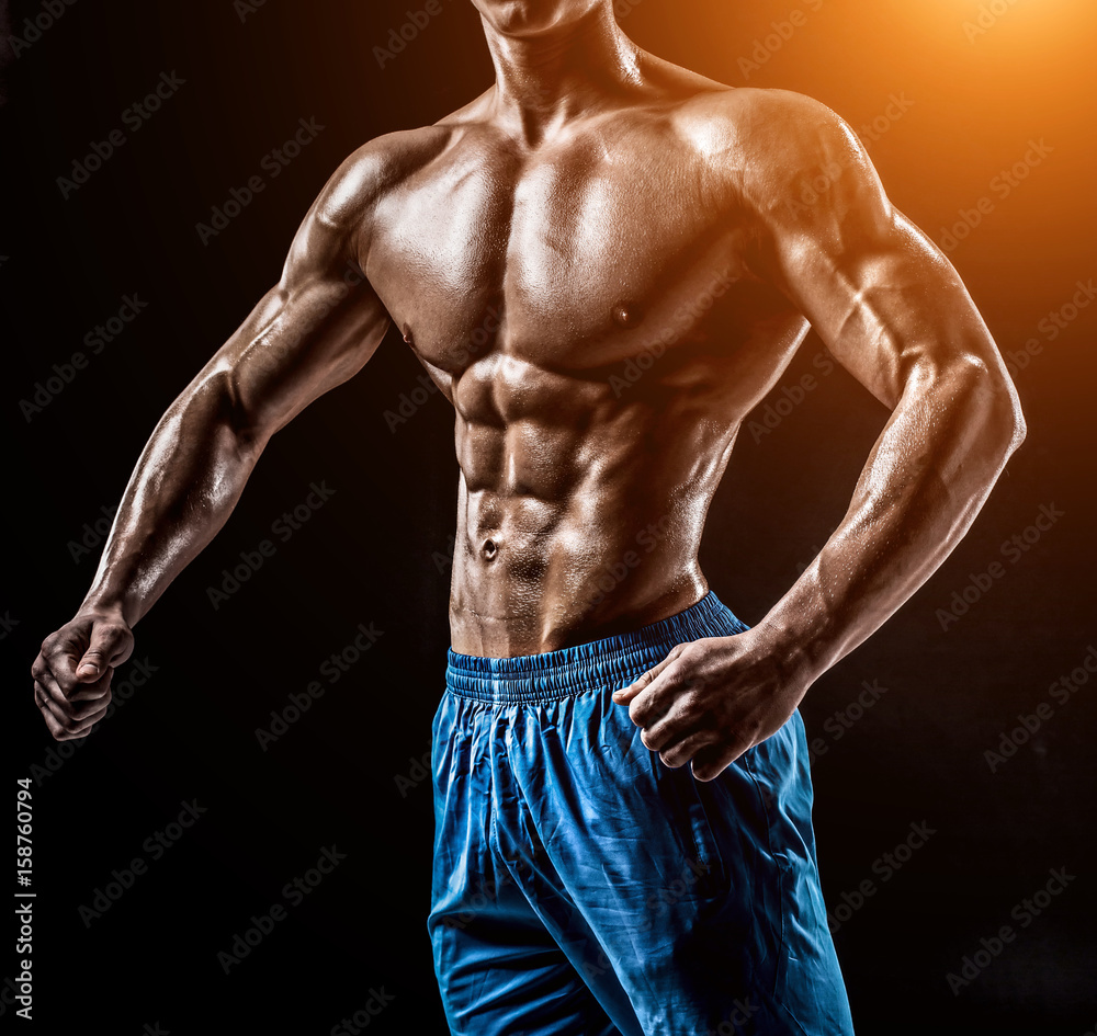 Fototapeta premium Muscular and fit young bodybuilder fitness male model posing ove