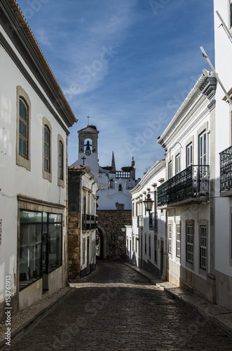  Europa, Portugalia, Algarve, miasto FARO - Tradycyjna wąska ulica. Wieczór, długie cienie. Na wprost dzwonnica. 