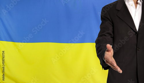 Open hand and Ukraine flag in the background