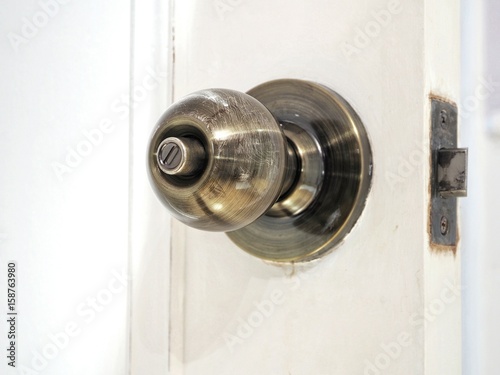 Modern retro doorknob on opened wooden door, closeup. Concept for room interior design.