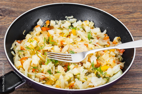 Stewed cabbage in frying pan with vegetables