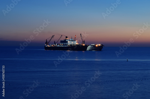 Silhouette of the ship over the sunrise photo