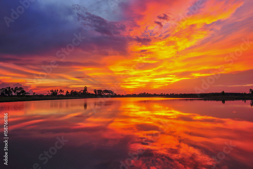 Cumulus sunset clouds with sun setting down © saravut