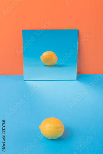 Lemon on blue table isolated over orange background