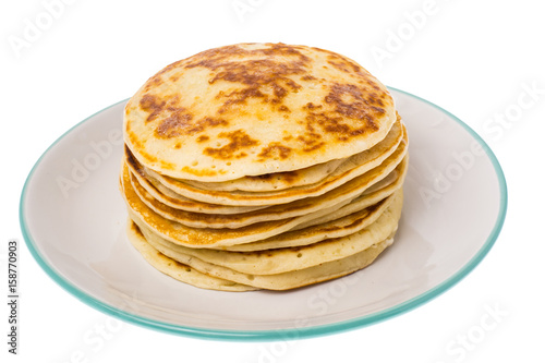 Stack of fried vanilla pancakes on plate on white background