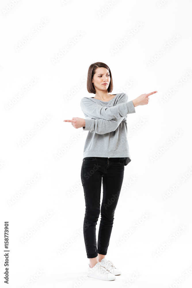 Frustrated young girl pointing fingers both ways Frustrated young girl pointing fingers both ways