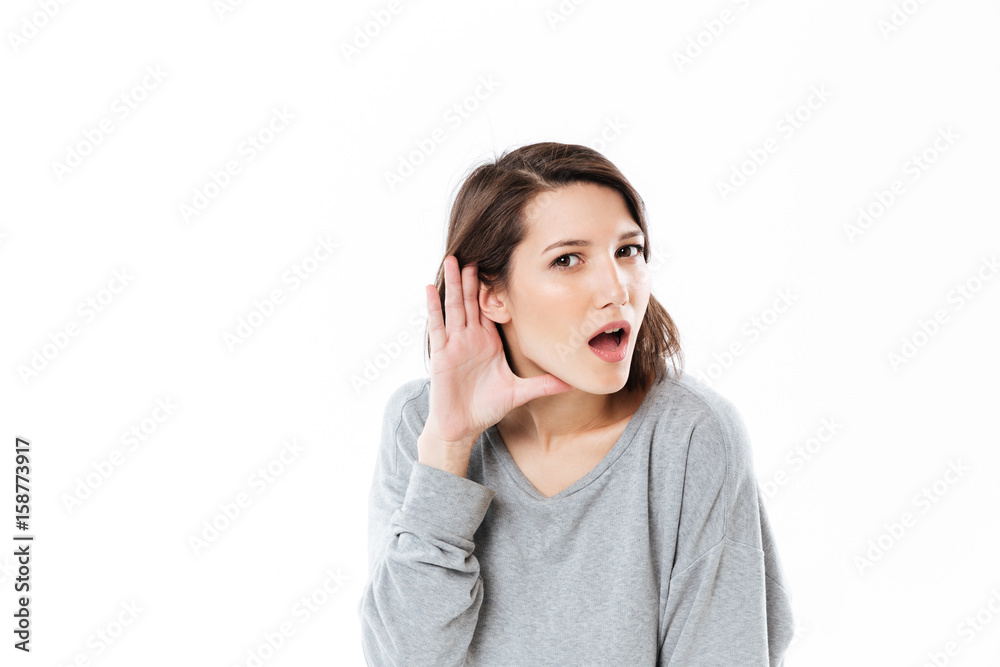 Young girl showing that she can not hear something clearly Young girl showing that she can not hear something clearly