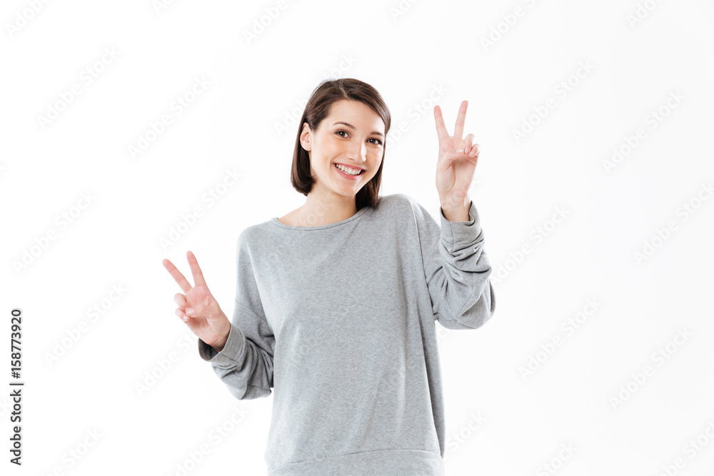 Smiling happy woman showing peace gesture with two hands Smiling happy woman showing peace gesture with two hands