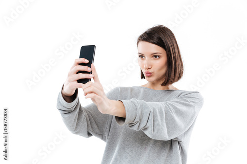 Pretty young girl taking selfie on mobile phone