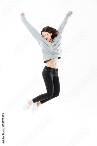 Portrait of a happy cheerful girl jumping and celebrating success