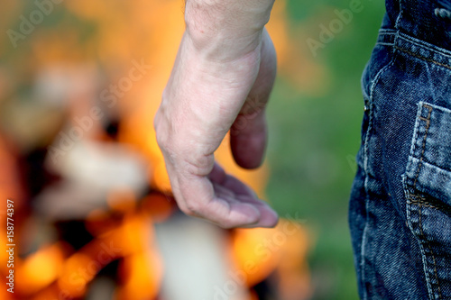 men's jeans on the background of fire, the man to fire