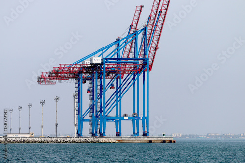 Cranes in seaport ship meets the sea
