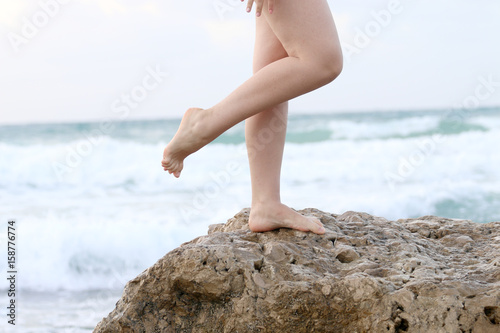 female legs against the background of the sea for advertising