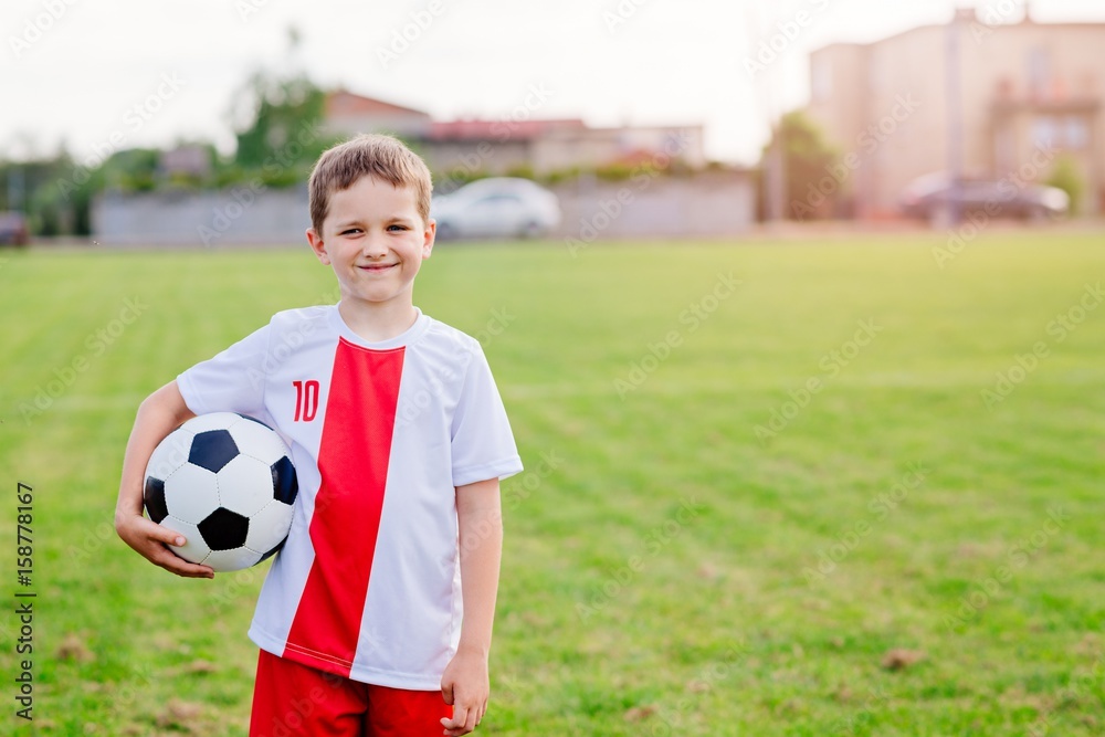 Naklejka premium 8 years old boy child holding football ball