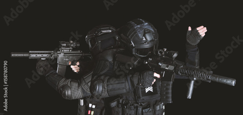 Members of the SWAT squad with an assault rifle in a black uniform on dark background. Special weapons and tactics. Special Forces.