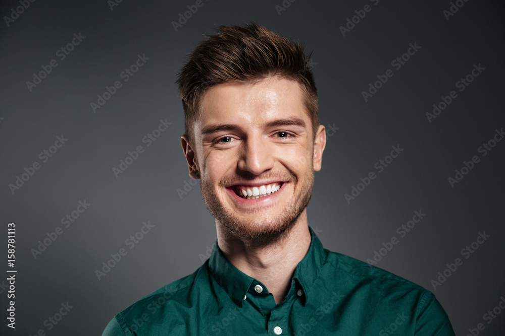 Cheerful young man posing isolated over grey background Cheerful young man posing isolated over grey background