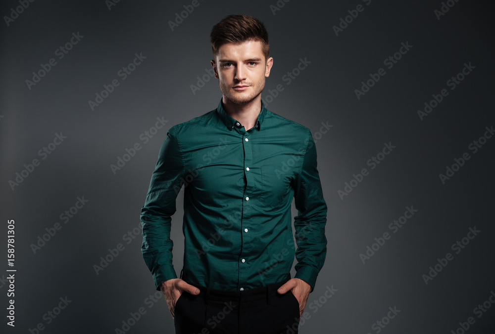 Handsome serious man dressed in shirt posing