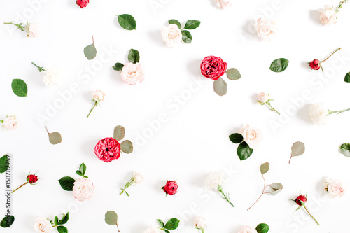 Round frame wreath pattern with red and beige rose flower buds, branches and leaves isolated on white background. Flat lay, top view. Floral background