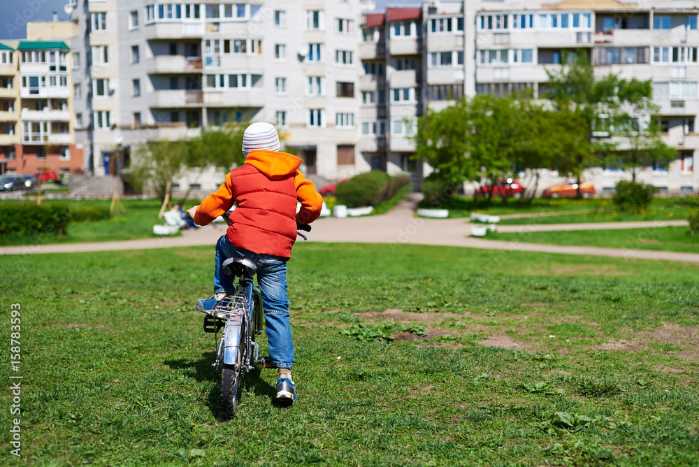 Fototapeta premium Small boy ride bicycle in street park.