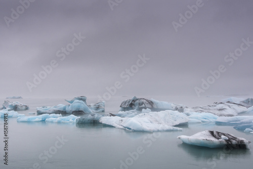 Big blue icebergs in Jokulsarlon glacier lake lagoon in the mist. Iceland.