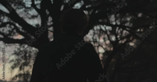 Bearded man walking at sunrise in silhouette