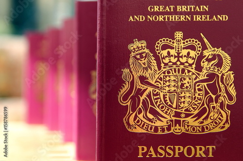 Five British United Kingdom European Union Biometric passports queueing in a line in shallow focus