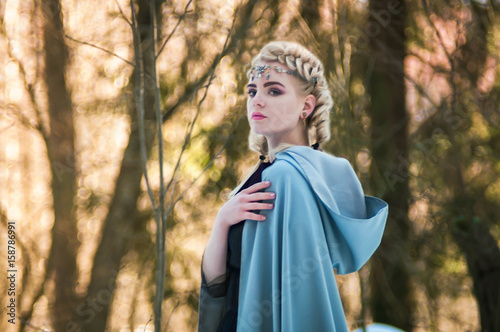 Fantasy elf girl in spring in a sunny forest