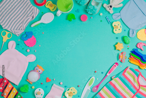 Baby accessories and clothes over turquoise background with copy space