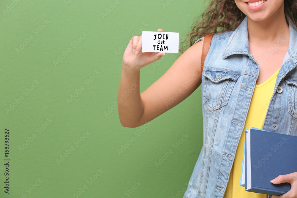 Female student with business card on color background