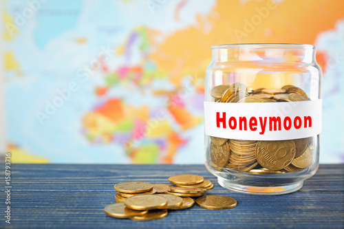 Glass jar with money on wor...
