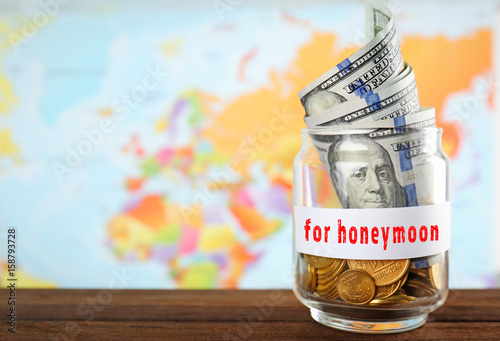 Glass jar with money on wor...