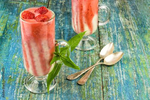 Summer strawberry dessert of a smuza with strawberry and mint on a wooden background photo