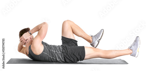 Handsome man doing bicycle crunch on white background photo