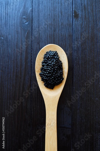 Black caviar in a large wooden spoon
