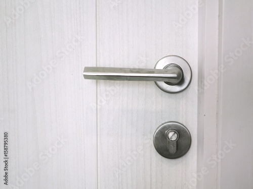 Door handle with lock on the white door, closeup. Concept of interior design modern room.