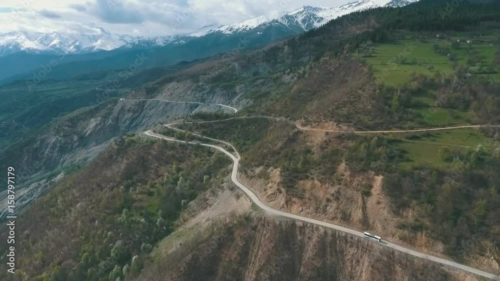 a bus traveling on a mountain road,shot from the air a bus traveling on a mountain road,shot from the air