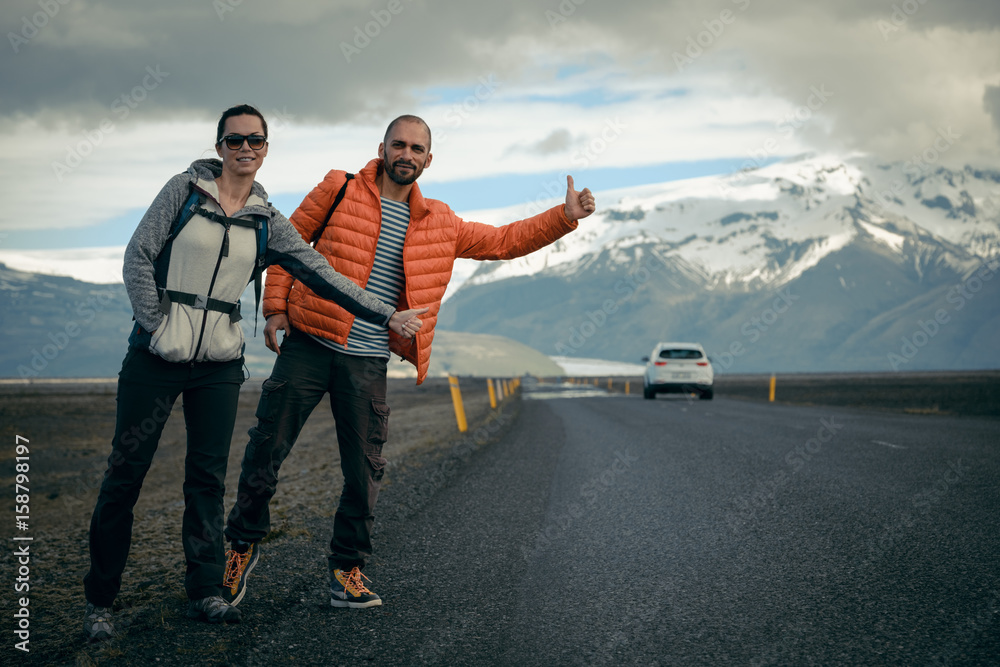 Travel hitchhiker couple on a road