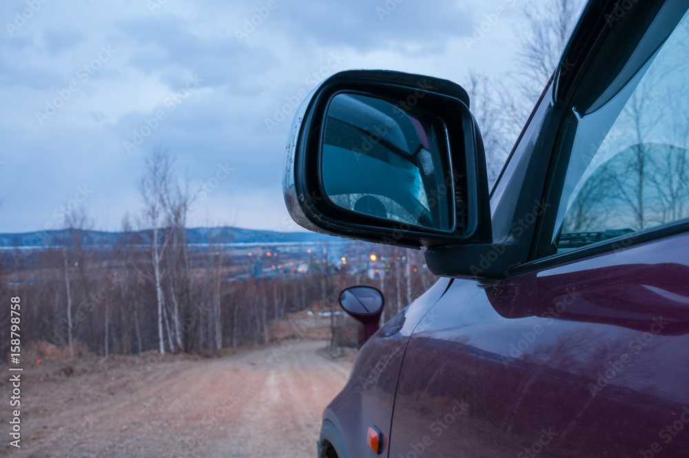 Obraz premium The car goes on a suburban road in evening