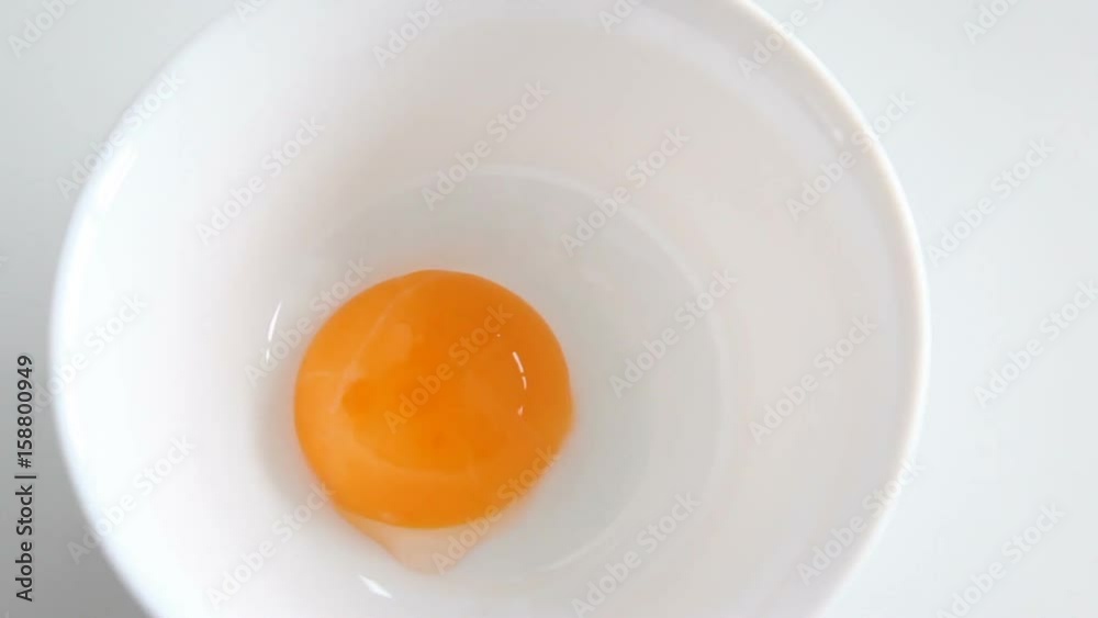 Egg yolk falling in glass bow.Preparing ingredients for baking cake. Cooking food. Fresh organic eggs falling into bowl. Food ingredient. Egg yolk falling in glass bow.Preparing ingredients for baking cake. Cooking food. Fresh organic eggs falling into bowl. Food ingredient.