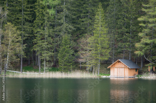 A small boathouse on the shore of a beautiful mountain lake