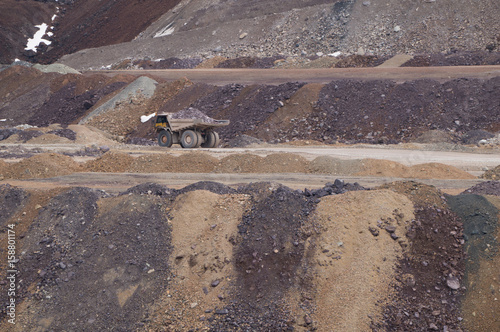 Large mining truck carrying ore across an open pit mine
