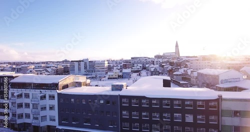 Ascending aerial, coastal city in Iceland at sunset