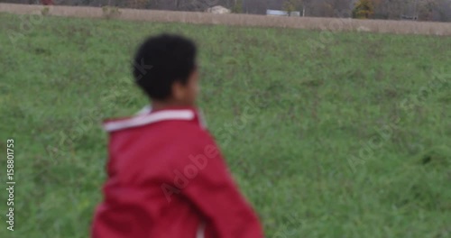 Angry boy throws backpack in field, slow motion
