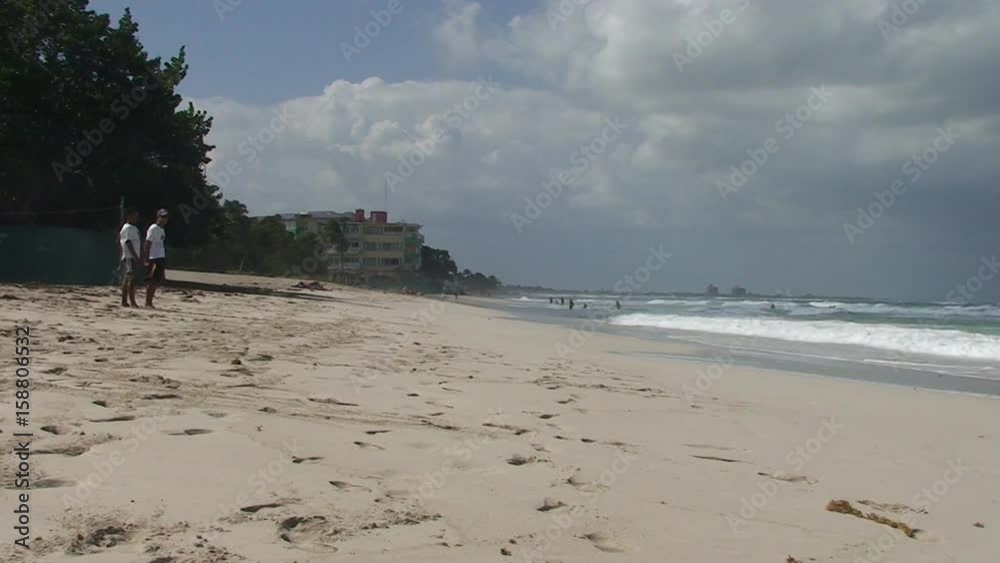Lifeguards stand on beach in Varadero, Cuba, pan right