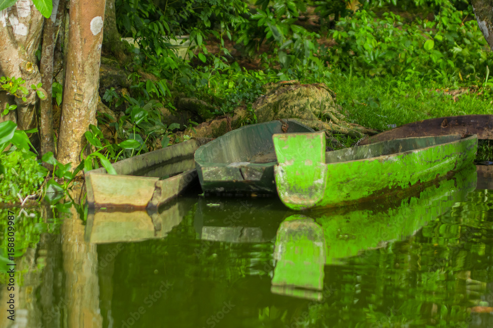 Old green fishing wooden boat in a calm lake water Old green fishing wooden boat in a calm lake water