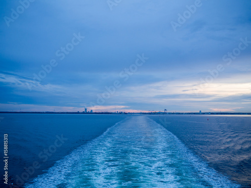 Sea water movement from ship sailing, sunset light